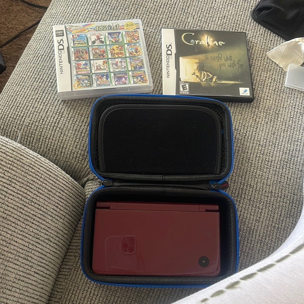 Nintendo DSi XL maroon colored with multi-game card and rare coraline game card